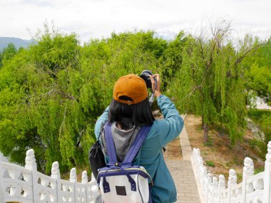 Qingxi rezervuarından Jade Dragon Kar Dağı 'nın fotoğrafını çeken bir turist. Lijiang, Yunnan, Çin