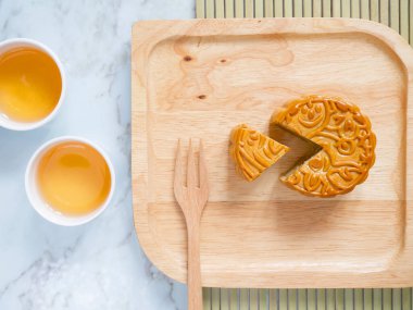 Sonbahar ortası festivali ya da Ay çöreği festivali için içinde çay olan ahşap bir tabakta ay çöreği. Üst görünüm.