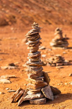 Parlak turuncu terk edilmiş boksit madeninde dağcılar tarafından istiflenmiş taşlar.