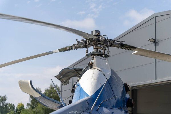 Главный ротор голубого вертолета с открытым капотом