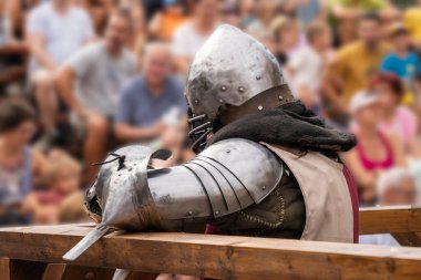 Medieval knight resting in armor at a jousting tournament