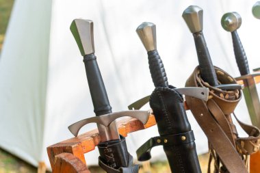 Ortaçağ kılıçları canlandırma olayında ahşap raflarda sergilenir.