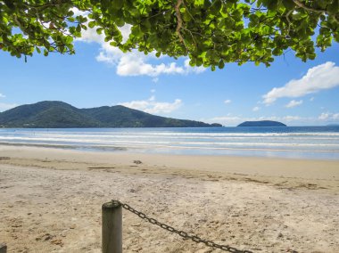 Güneş gün plajda, mavi gökyüzü ve ada içinde belgili tanımlık geçmiş ile.