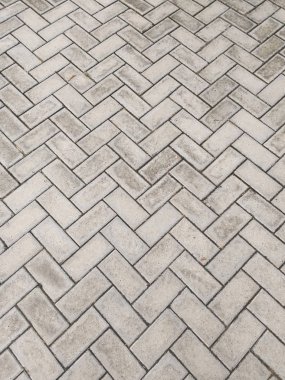 Dikdörtgen çimento bloklar dokusuna buruk bir zikzak desen gömülü.