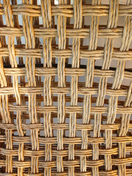 Close up of braided on strings of straw, with shadows.