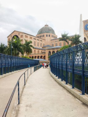 27 Aralık 2018, Aparecida Şehri, Sao Paulo, Brezilya, Our Lady Aparecida Ulusal Tapınağı. Bulutlu bir günde yürüyen hacıların olduğu yaya köprüsünün görünümü.