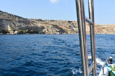 Denizde bir teknenin yakın çekimi. Tatil sırasında sürat teknesi gezisi. Tekne kiralama. Rodos, Yunanistan. Denizde yaz tatili. Turist tekne gezisi. Denizden gelen Rodos Panoraması.