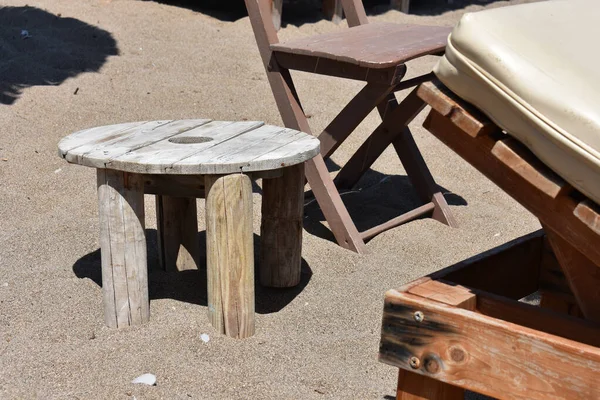 Rhodes Adası 'ndaki Stegna plajı. Yunanistan 'da kumlu bir plajda güneşlenmek. Tahta güneşlikler, masa ve sandalye. Yunanistan 'da tatiller. Rodos 'a git. Yaz ve tatiller. Rahatla.. 