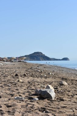 Akdeniz 'deki Afandou köyü yakınlarındaki çakıl ve kumsal, Rodos Adası, Yunanistan. Dağ manzaralı deniz manzaralı. Yunanistan 'da turizm ve plaj tatilleri. Temiz su ve çakıl taşı plajı. Yunanistan 'a Seyahat. 