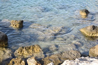 Historic port of Mandraki on the island of Rhodes, Greece. Rocks and water. Natural background. Abstract background. Mediterranean Sea, Rhodes Island, Greece. Summer and holidays. 