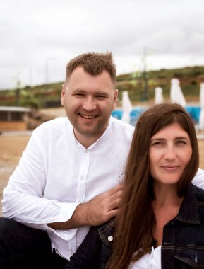 Mutlu çiftin portresi gökyüzü arka planında. Kendinden geçmiş, güzel genç bir çift, iki arkadaş, aile babası, beyaz elbiseli bir adam ve bir kadın, el ele tutuşuyorlar, koşuyorlar, gün doğumunda deniz üzerinde birlikte yürüyorlar.