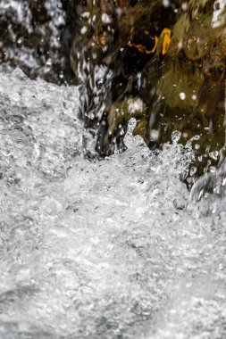 Kayalık bir yüzeye yakın su sıçratma görüntüsü.