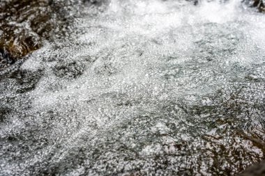 Bir derede kaynayan suya yakın çekim, desenli bir yüzey oluşturur.