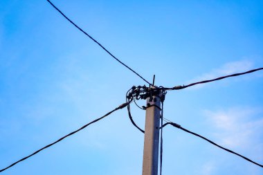 Beton direğe kabloluda modern yalıtılmış elektrik kablo mavi gökyüzü arka plan ile bir elektrik direği monte. farklı yönlere, birçok yolu vardır, tek bir zincir bağlantıyı geliştirme.