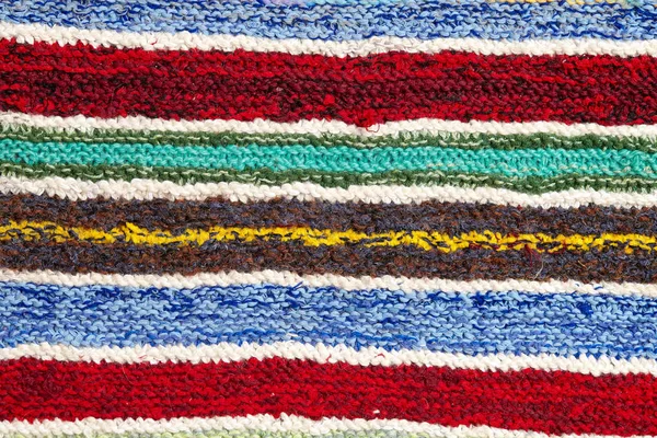 farklı renkli çizgili örme kumaş yüzeyinde. Tekstil retro close-up arka plan halı veya kilim. kumaş dokusuna satırların geometrisi ile bir kombinasyonudur. El yapımı ürün