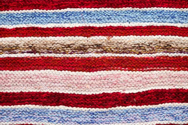farklı renkli çizgili örme kumaş yüzeyinde. Tekstil retro close-up arka plan halı veya kilim. kumaş dokusuna satırların geometrisi ile bir kombinasyonudur. El yapımı ürün