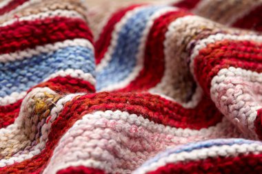 farklı renkli çizgili örme kumaş yüzeyinde. Tekstil retro close-up arka plan halı veya kilim. kumaş dokusuna satırların geometrisi ile bir kombinasyonudur. El yapımı ürün