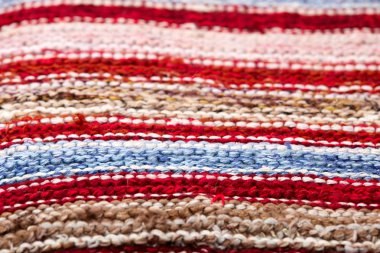 farklı renkli çizgili örme kumaş yüzeyinde. Tekstil retro close-up arka plan halı veya kilim. kumaş dokusuna satırların geometrisi ile bir kombinasyonudur. El yapımı ürün
