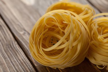 Pişmemiş fettuccine makarna top, dokulu ahşap zemin üzerinde. birkaç farklı foreshortenings kümesi