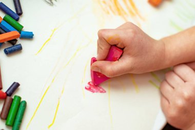 Çocuk bir çiçek ile yapılan mum boya kalemi ile kağıt üzerinde çizer