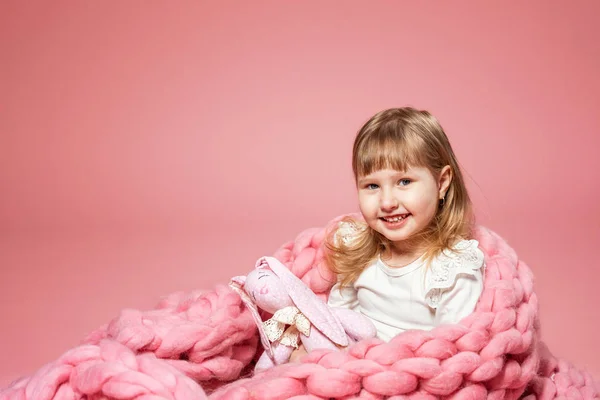 Happy baby på rosa korall bakgrund täckt med filt och Mer — Stockfoto