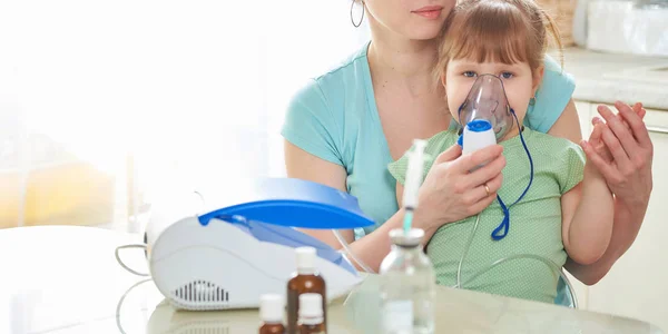 Mulher faz inalação para uma criança em casa. traz o nebulizador — Fotografia de Stock