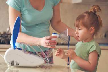 bir kadın bir çocuk evde inhalasyon yapıyor. nebulize getiriyor