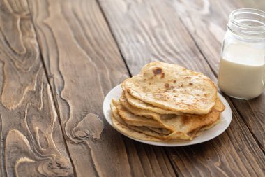 bir fincan süt ve bir tabak kızarmış Mısır ekmeği ahşap bir metin üzerinde