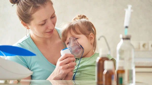 Γυναίκα κάνει εισπνοή ένα παιδί στο σπίτι. φέρνει το νεφελοποιητή — Φωτογραφία Αρχείου