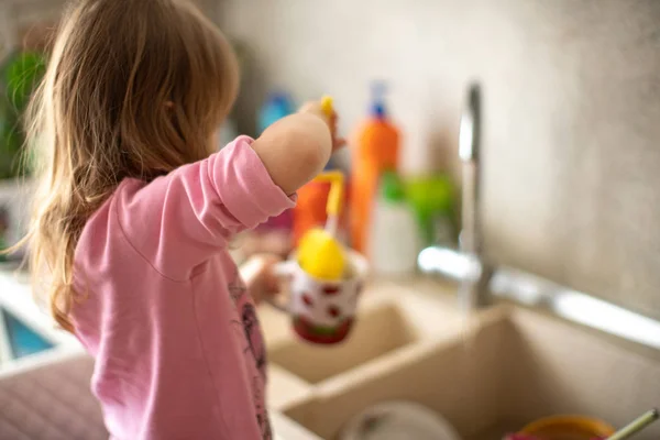 Child washes dishes, help in the kitchen, new experience getting — Stock Photo, Image