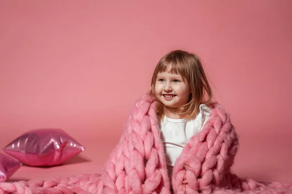 Happy baby på rosa korall bakgrund täckt med filt och Mer — Stockfoto