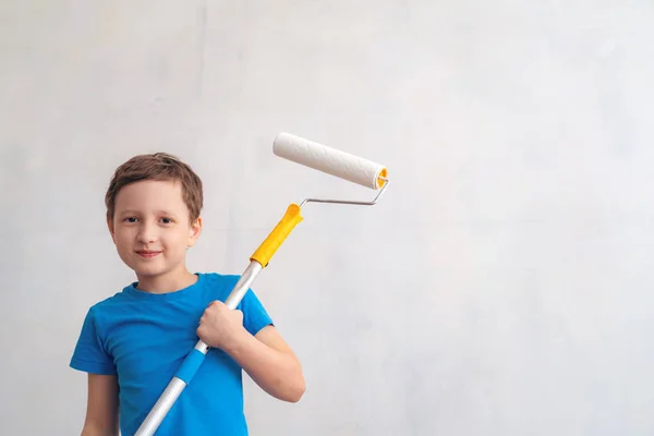 Child rolls the roller in the paint on the wall. finishing work — Stock Photo, Image