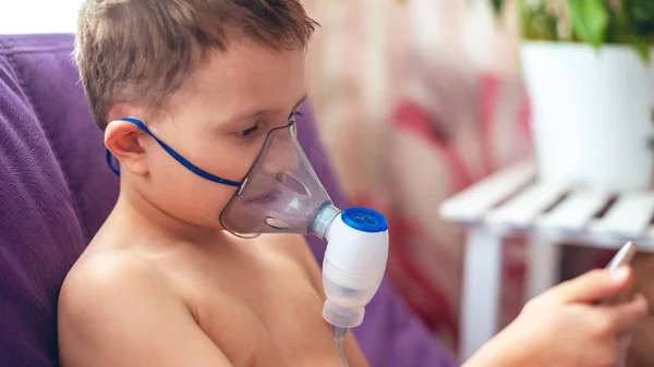 Niño hace nebulizador de inhalación en casa. en la cara con un —  Fotos de Stock