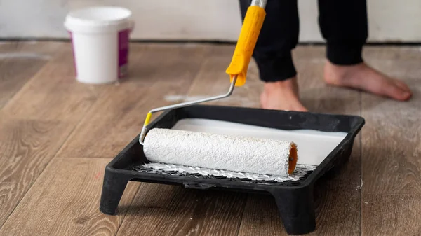 Child rolls out a roller paint in a special tray Kuwait. finishi — Stock Photo, Image