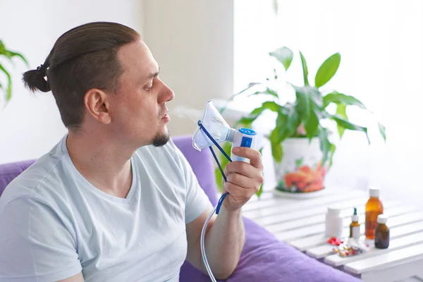 Un hombre enfermo respira a través de una máscara inhaladora —  Fotos de Stock