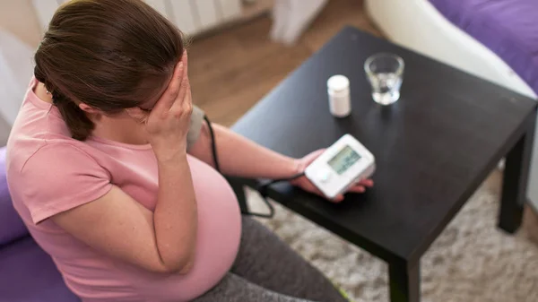 Una donna misura la pressione sanguigna con un manometro elettronico — Foto Stock