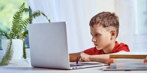 Niño está buscando información en Internet a través de un lapto — Foto de Stock