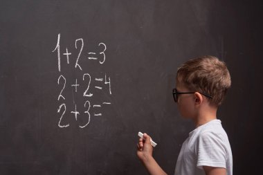 Ilköğretim. Bir öğrencinin arka görünümü bir matematik çözer