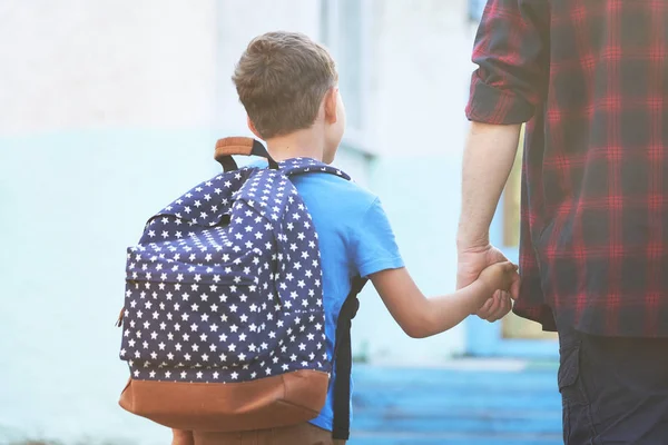 Fadern åtföljer barnet till skolan. en man med ett barn avtagbar — Stockfoto