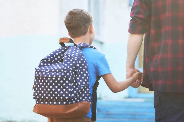 father accompanies the child to school. a man with a child remov