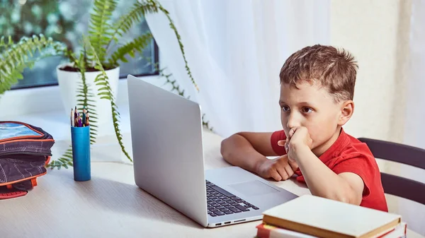 Niño está buscando información en Internet a través de un lapto — Foto de Stock