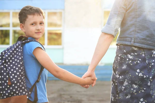 Moeder begeleidt het kind naar school. moeder moedigt student een — Stockfoto