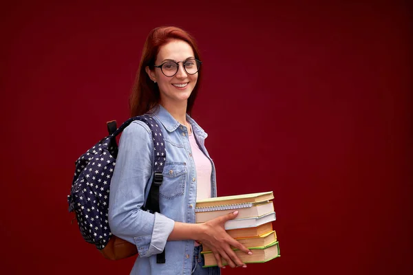 Портрет красивой студентки с рюкзаком и стопкой — стоковое фото