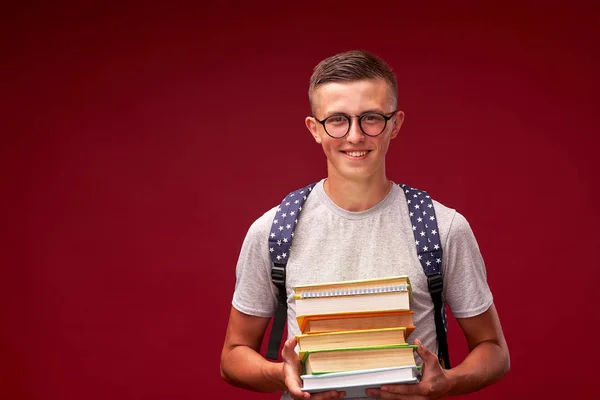 Retrato de un niño estudiante con una mochila y una pila de libros i —  Fotos de Stock