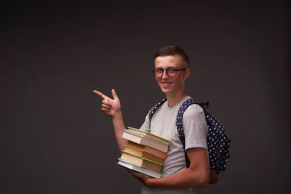 Веселый студент-подросток улыбается, держа книгу в руке и p — стоковое фото