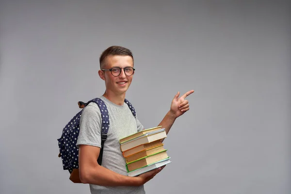 Vrolijke tiener student lachend houden een boek in zijn hand en p — Stockfoto
