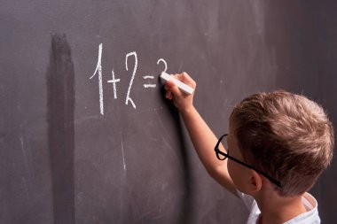 Ilköğretim. Bir öğrencinin arka görünümü bir matematik çözer