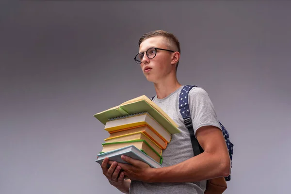 Retrato de un niño estudiante con una mochila y una pila de libros i —  Fotos de Stock