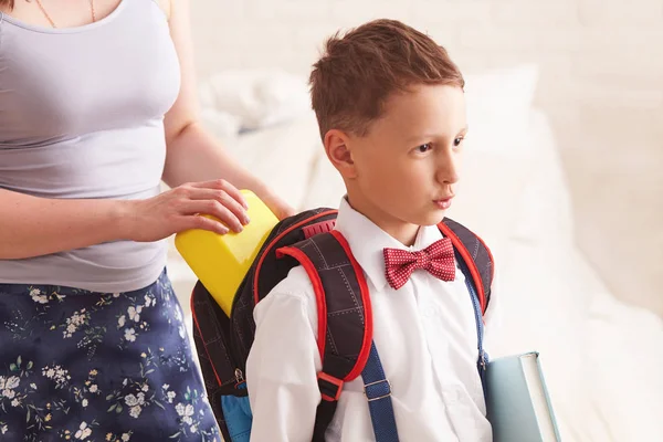 mom puts a Packed school lunch in a plastic box for her son