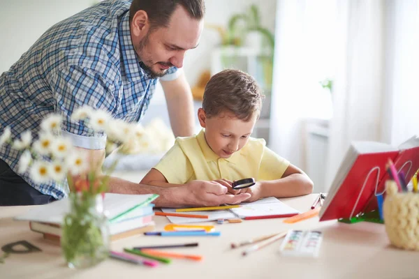 Papa aide son fils à faire ses devoirs. enseignement à domicile, cours à domicile . — Photo